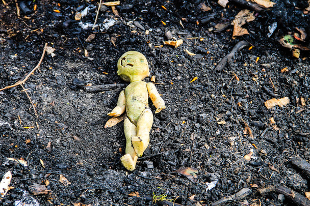Muñeca rota vieja abandonada sobre fondo de ceniza gris
 - Foto, Imagen