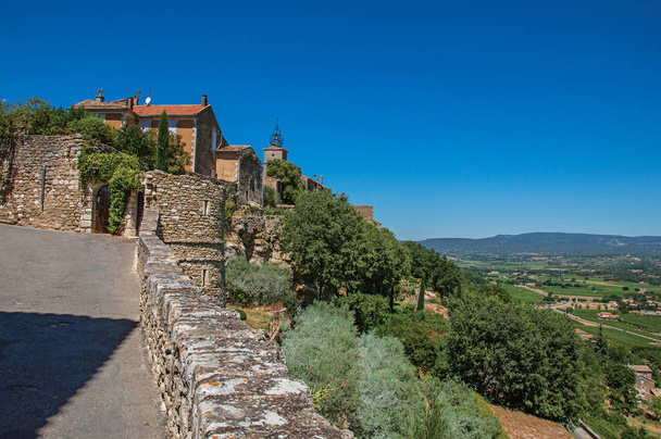 Panoramik sokak, ev ve Provence tepelerinde Menerbes Köyü, güneşli mavi gökyüzü altında. - Fotoğraf, Görsel