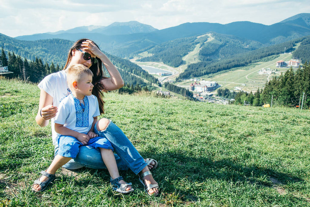 madre con figlio in ginocchio seduta in cima alle montagne
 - Foto, immagini