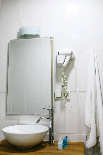 Ванная комната в отеле со всеми необходимыми принадлежностями для ванной комнаты для туристов
. - Фото, изображение