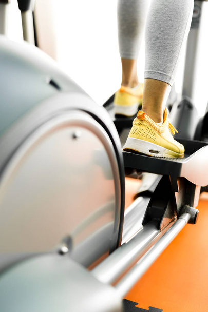 Closeup of a woman using a stepper and training in a gym - Fotó, kép
