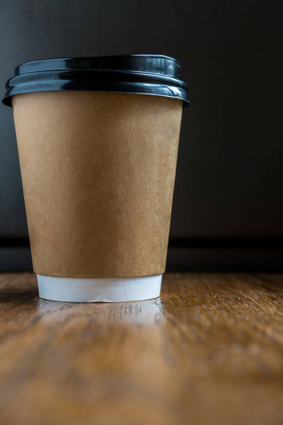 Einweg-Kaffeetasse auf einem Holztisch - Foto, Bild