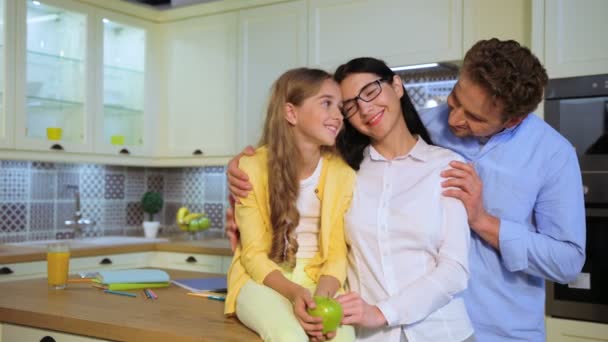 Jovem família caucasiana feliz sorrindo e possuindo na câmera na cozinha
. - Filmagem, Vídeo