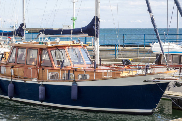 Fából készült vintage kék yacht áll közel a mólón - Fotó, kép
