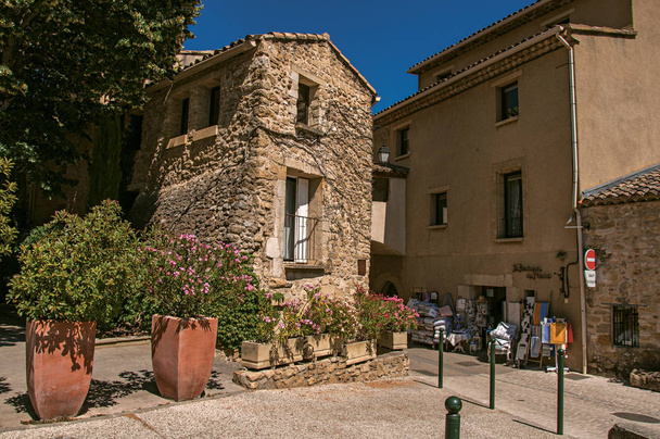 View of quiet alley with stone buildings and shops in the lovely village of Lourmarin.Europe, France, Vaucluse, Provence, Lourmarin, blue sky, building, facade, house, historical, journey, roof, stone, summer day, sunny day, clear sky, street, alleyw - Fotografie, Obrázek