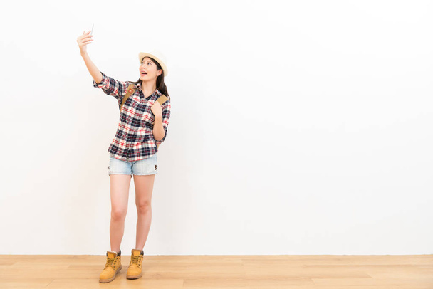 彼女の携帯電話を使用して幸せな女子学生 selfie - 写真・画像