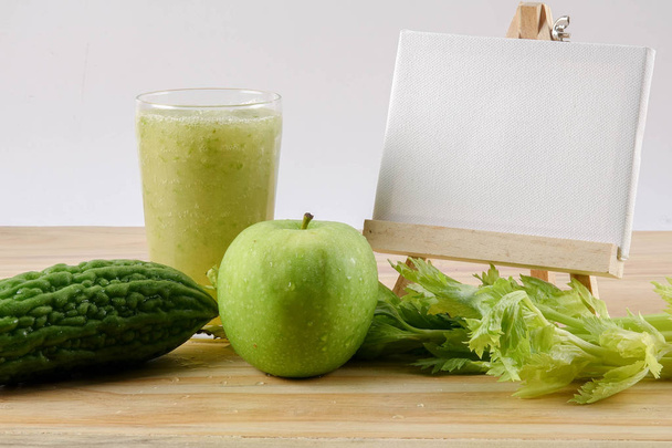 Green apple, bitter gout and celery isolated on wooden background to control diabetic naturally. Health concept. - Photo, Image