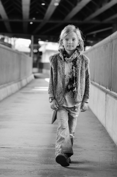 Fiatal csinos kis lány az utcán. Fekete-fehér portréja - Fotó, kép