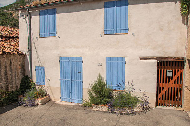 View of house with blue shutters closed in the charming village of Moustiers-Sainte-Marie. - Φωτογραφία, εικόνα