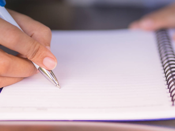 Mulher mão escrita com caneta branca na mesa de trabalho. Conceito de negócios e educação
. - Foto, Imagem