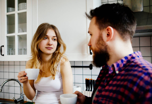 Young couple is drinking tea and coffee at home - Fotó, kép