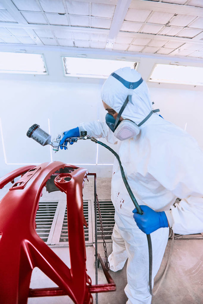 Painting bumpers machine red in the paint shop. - Φωτογραφία, εικόνα