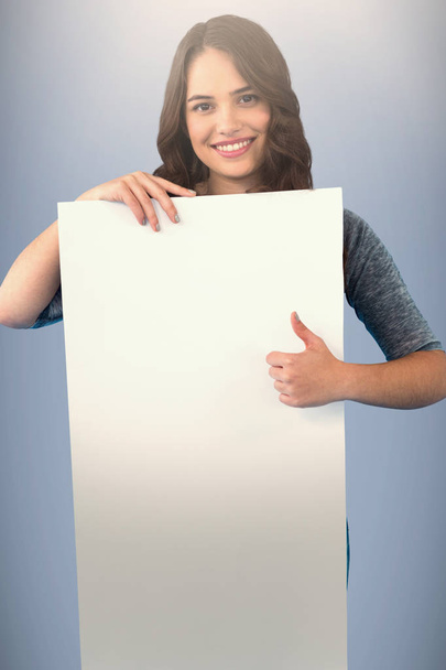 Brunette woman holding blank poster  - Фото, зображення