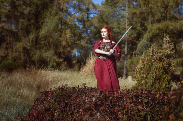 Στο δάσος, μια γυναίκα με ένα σπαθί. - Φωτογραφία, εικόνα