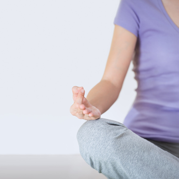 Closeup part of female body meditating. Focus on fingers - Foto, Bild