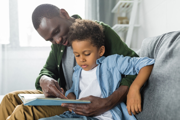 Vater und Sohn lesen gemeinsam Buch - Foto, Bild
