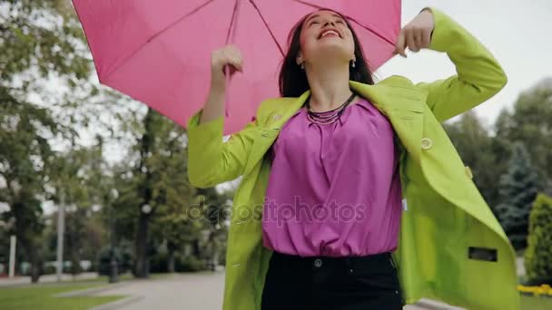 Woman rejoice a not rainy weather under umbrella in city alley at overcast summer or autumn day - Filmati, video