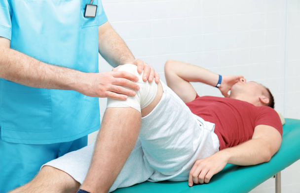 Orthopedist examining patient in clinic - Photo, image