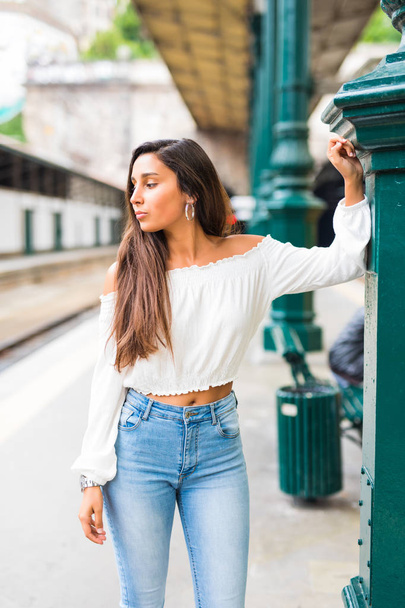 Young woman posing at platform on train station. Waiting a train or metro - Photo, Image