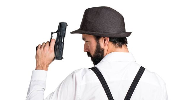Hipster άνδρας με γενειάδα με ένα πιστόλι - Φωτογραφία, εικόνα