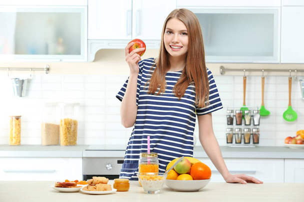Jovem bela mulher tomando café da manhã na cozinha
 - Foto, Imagem
