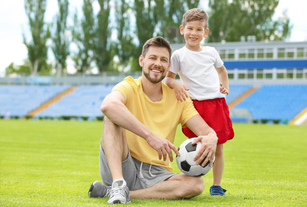 Dad and son with soccer ball in stadium - Zdjęcie, obraz