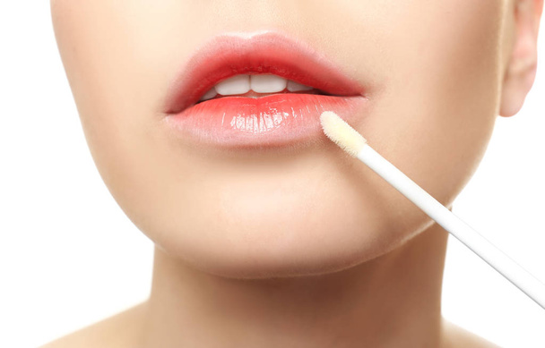 Young woman applying lip gloss - Photo, Image