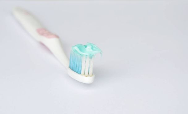  pasta de dientes poner en cepillo de dientes en fondo blanco
 - Foto, imagen