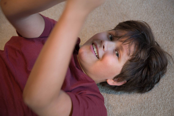Happy teen boy laying carpet smiling  closeup - Photo, Image