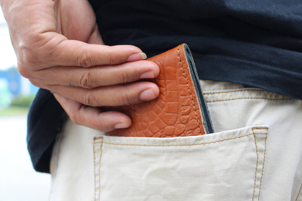 man picking wallet from jeans pocket - 写真・画像