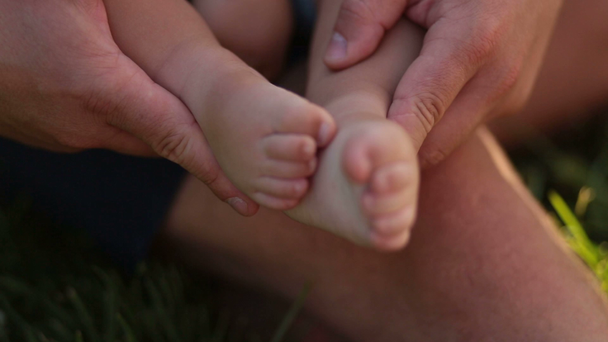 Kleine baby voeten in zorgzame handen van vaders - Video