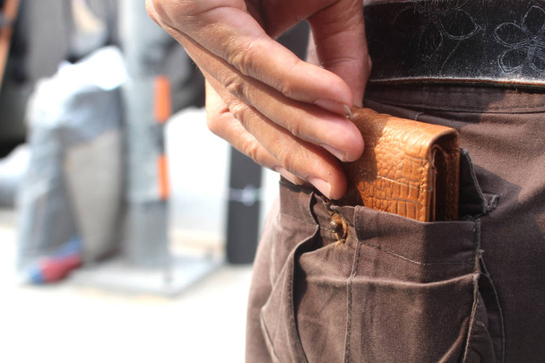 man picking wallet from jeans pocket - Fotó, kép