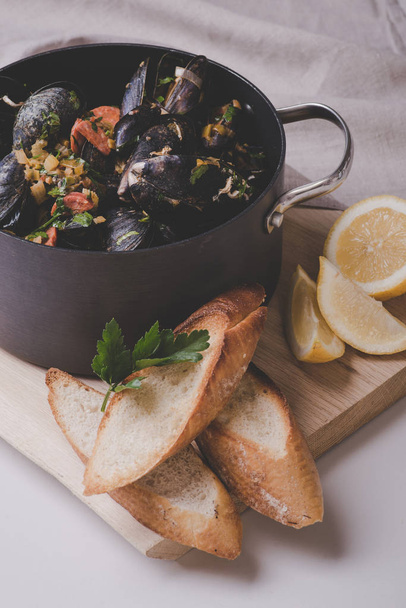 Freshly cooked sea mussels in deep casserole - Fotó, kép