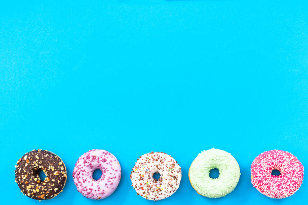 Colorful donuts border background, top view flat lay - Foto, Imagem