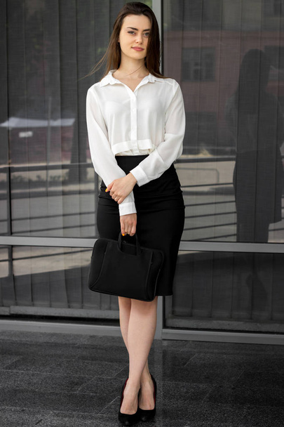 beautiful young Office women in a white shirt and skirt stands on the street - Photo, image