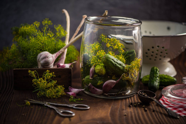 Ingredients for pickled cucumbers on wooden table - Photo, image