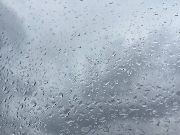 Rain drops on window against moody sky - Photo, Image