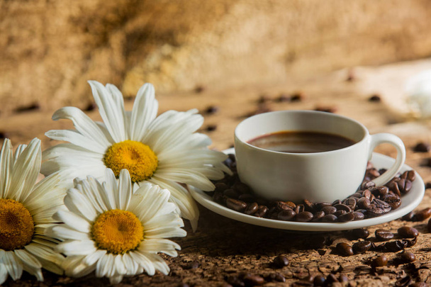 Coffee. A cup of coffee with grains on a wooden background - Fotografie, Obrázek