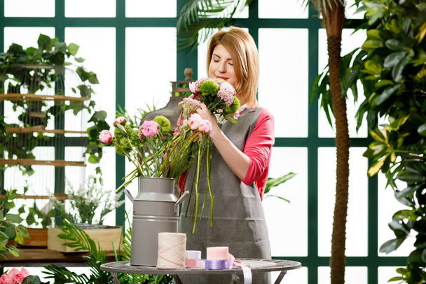 Woman making composition of flowers - Photo, image