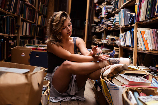 Portrait of ballerina girl in vintage book store wearing casual clothes - Zdjęcie, obraz