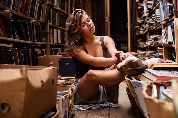 Portrait of ballerina girl in vintage book store wearing casual clothes - Foto, immagini