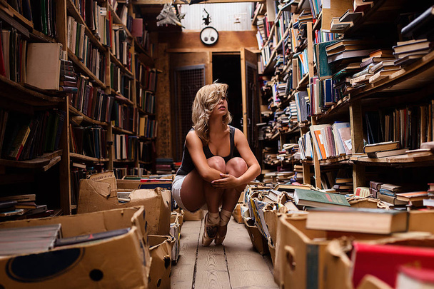 Portrait of ballerina girl in vintage book store wearing casual clothes - Фото, изображение