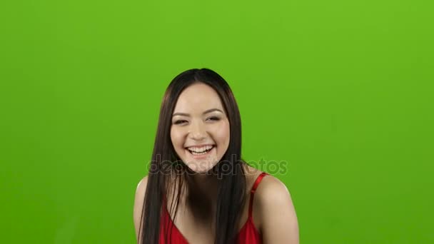 Asian girl is having fun and laughing loudly at her beautiful smile. Green screen - Materiał filmowy, wideo