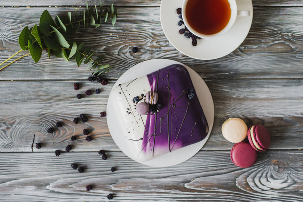 Традиционный фиолетовый ягодный торт и макаронный суфле и миндальный дакуаз, малиновый конфет, хрустящий слой с карамельными фундуками и малиновым порошком, мусс на основе горького шоколада подается
 - Фото, изображение
