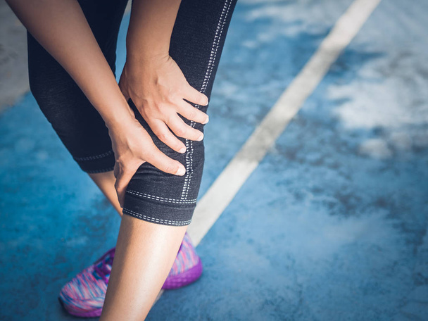 Corredor de cerca lesión de rodilla deportiva. Una mujer con dolor mientras corre. Concepto de lesiones deportivas
. - Foto, imagen