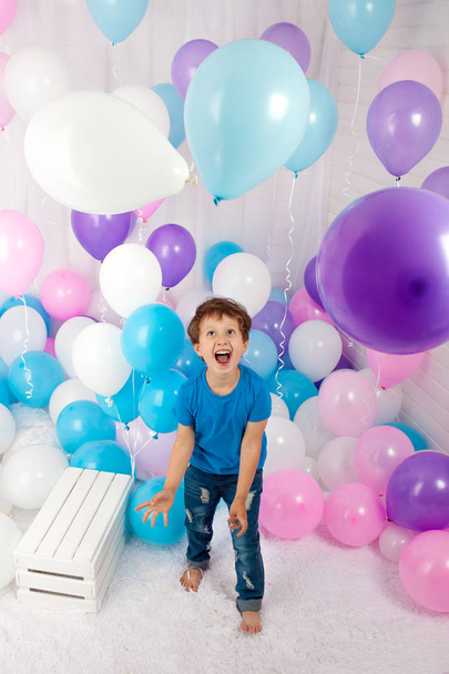 Hilarious boy with bunch of colorful balloons. Playing with balloons. Isolated on white. - Zdjęcie, obraz
