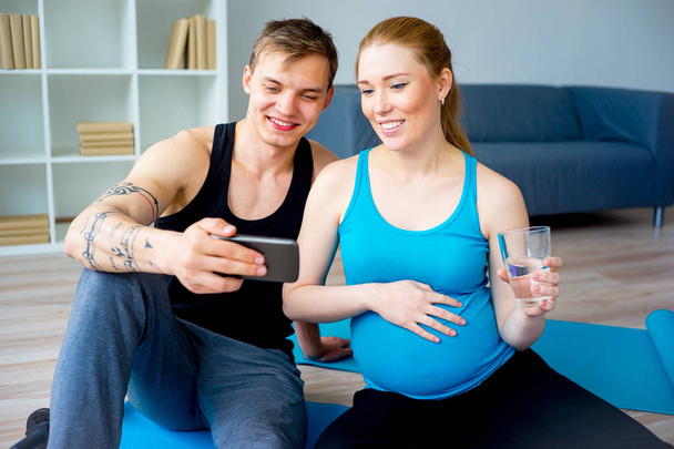 Pregnant woman doing exercises with her husband - Photo, Image