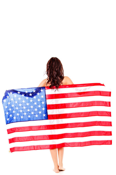 Beautiful brunette woman wrapped into American flag. - Photo, Image