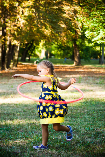 malá holčička hrát s obručí v parku - Fotografie, Obrázek