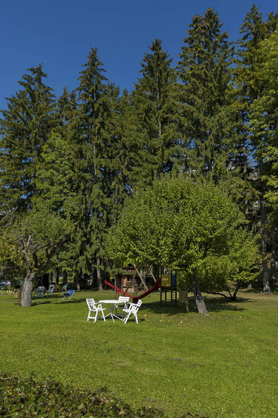 Podzimní pohled směrem k veřejné zahrady s piknikový stůl na trávníku židle, strom a pod širým nebem školky, Cortina d'Ampezzo, Alpy, Dolomity, Veneto  - Fotografie, Obrázek